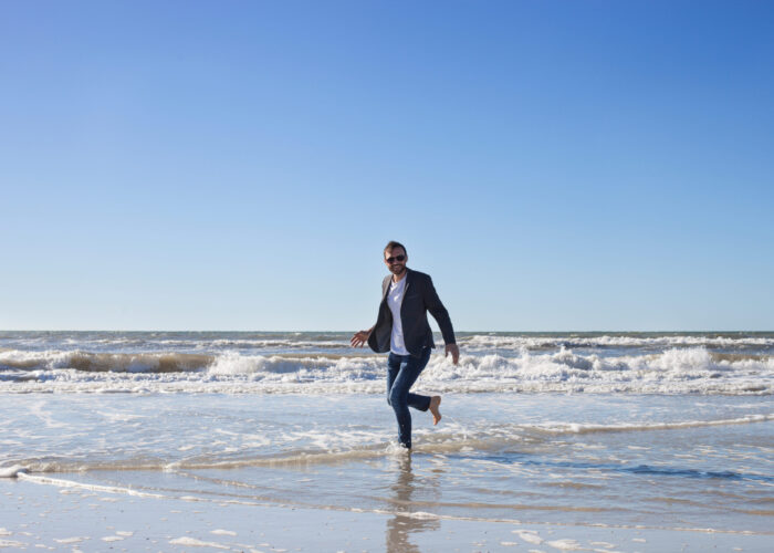 Handsome,Businessman,Walking,On,The,Beach,,Business,Travel,Concept.